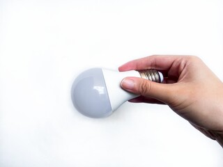 Hand holding modern LED light bulb on white background. Perfect for illustrating energy efficiency,...