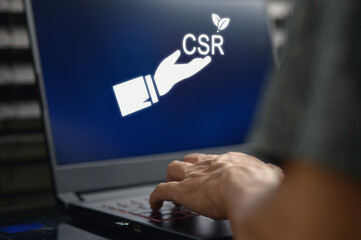 Hand Reaching for CSR Concept on Laptop Screen Showing Social Responsibility