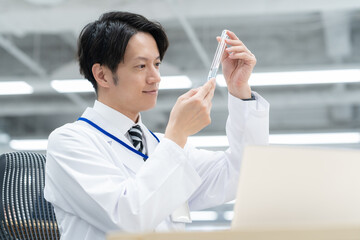 実験をする若い白衣の男性研究者