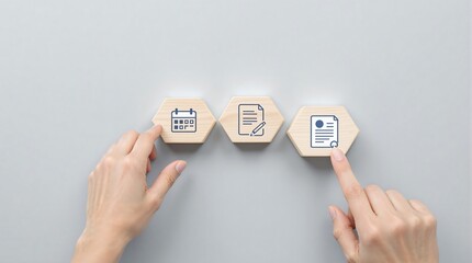 Hands interacting with wooden hexagon blocks depicting calendar document and agreement icons