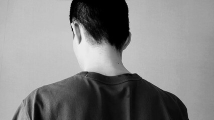 落ち込む日本人男性の後ろ姿をイメージ