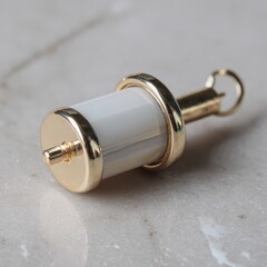 A gold and white pendant with a gold chain