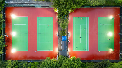 Aerial View of four Tennis Courts Lit Up for Night Play Outdoor
