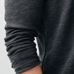 A person is wearing a black shirt with a gold stripe