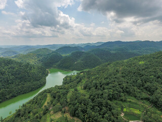 Aerial View Of Emerald Green River Flowing Through Rolling Majestic Lush Verdant Landscape Captured...