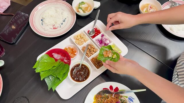 Preparing Miang Kham Savory Leaf Wraps at Dining Table