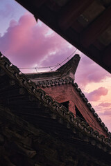 Unique architectural features of traditional Chinese temple rooftops at dusk