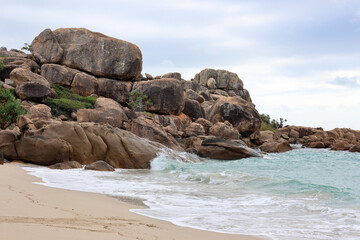 Weathered boulders rocks next to the ocean at Horseshoe Bay beach near Bowen in Queensland, Australia