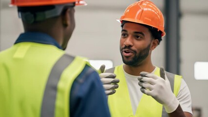 A smiling construction worker in a hard hat and safety vest happily discusses a project with a colleague in an industrial setting - Powered by Adobe