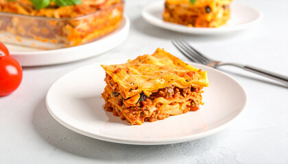 A delicious square slice of homemade Italian meat lasagna on a white plate.