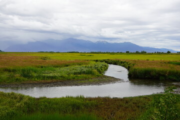 landscape with river  backed by foggy misty mountains in Alaska 