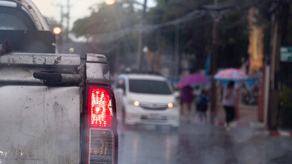 Abstract traffic conditions during the foggy rain. Rear of dilapidated pickup truck with turn on...