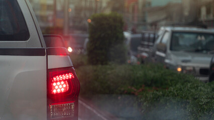Abstract traffic conditions during the foggy rain. Rear side of pickup car with turn on brake...