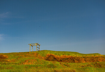 Bamboo Frame on Lush Green Hilltop Under Blue Sky