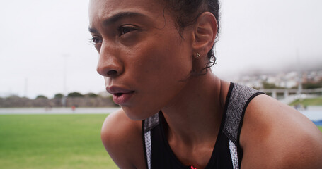 Tired, athlete and woman on field, breathing or training for marathon in morning, break and...