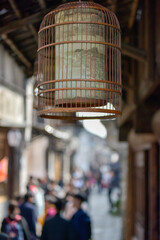 Traditional Bamboo Birdcage Hanging in a Bustling Ancient Street