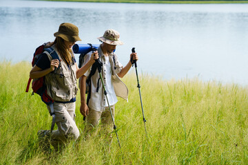 Man and woman are enjoy seeing a beautiful landscape and lake view while hiking.