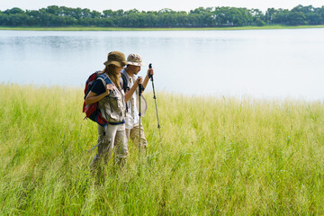 Man and woman are enjoy seeing a beautiful landscape and lake view while hiking.