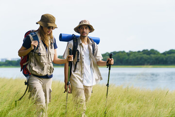 Man and woman are enjoy seeing a beautiful landscape and lake view while hiking.