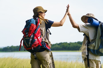 Man and woman are enjoy seeing a beautiful landscape and lake view while hiking.