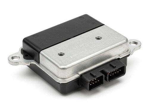 Close up shot of an electronic control module with black and silver housing on white backdrop