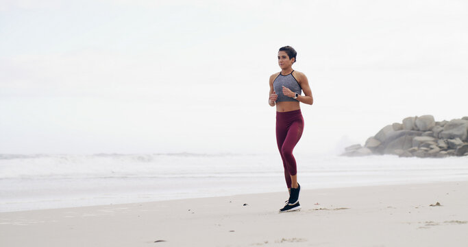 Woman, workout and run on beach for exercise, fitness or outdoor wellness or fresh air. Female person, athlete or runner with marathon, preparation and cardio training with space in nature for health - Powered by Adobe