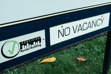No Vacancy sign on a certified rental building, highlighting high rental prices, less...