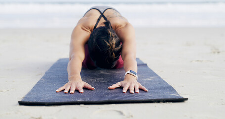 Woman, yoga and childs pose at beach in summer, mat and stretching muscle in morning at shore. Person, exercise and pilates training on ground, nature or fitness by ocean on vacation in New Zealand