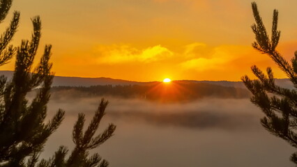 Sunny sunrise over the Ural mountains over the village of Inzer on a summer day