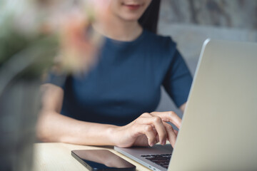 Woman typing on laptop computer, searching information, surfing the internet. Casual business woman...