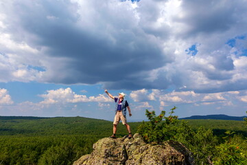 mature man tourist standing on top of cliff on ural ridge irendik sunny summer day