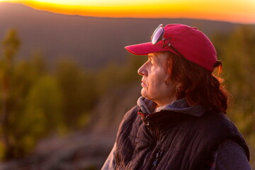 beautiful mature women in the mountains at sunset on a summer day