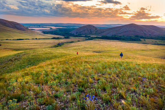 tourists walk along the ridge of karamuruntau against the backdrop of andreevskie cones in the evening at sunset