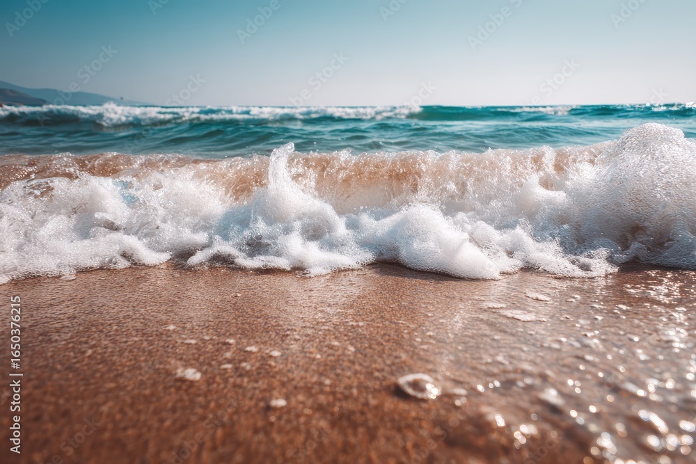 Canvas Prints waves crashing softly on the sandy beach with a serene ocean backdrop under a clear sky during a bri