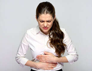 a woman age 25 grimacing with stomach pain