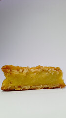 Slice of Lemon Pie with Golden Crust on White Surface
