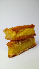 Two golden fried potato wedges stacked on white background