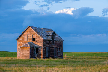Dark storm clouds over an old, abandoned home on the prairies north of Rush Lake, Saskatchewan