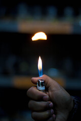 Hand Holding a Lighter with Flame