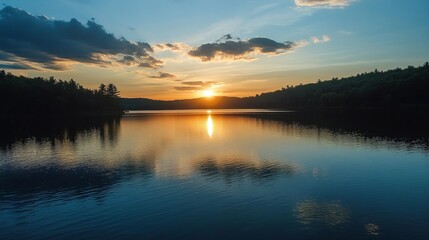 Fototapeta premium Serene sunset over a calm lake, silhouetted trees