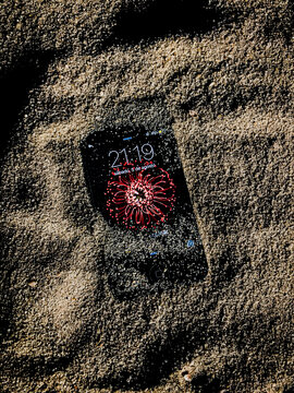Old smartphone under the sand