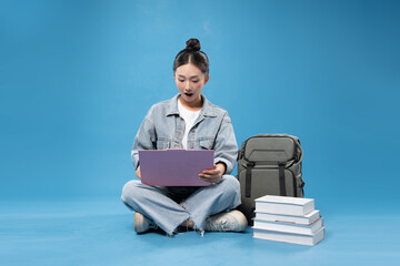 Excited young woman sitting cross-legged working on a laptop Modern learning and education