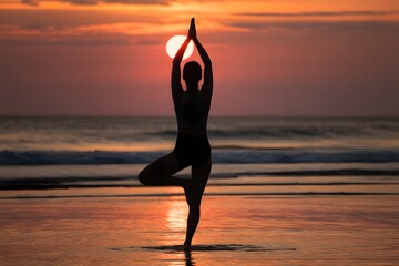 Silhouette of person in yoga tree pose on beach at sunset woman