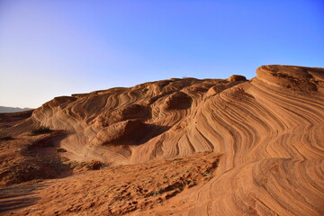 Sandy Dunes with Wavy Patterns Under a Clear Blue Sky