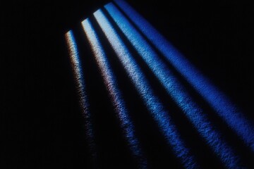 Dark room, light streaks through bars