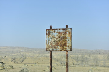 Rusty Signboard in an Arid Landscape