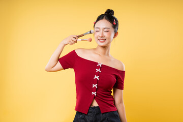 Cheerful woman with makeup brushes in studio with vibrant background Beauty and cosmetics theme