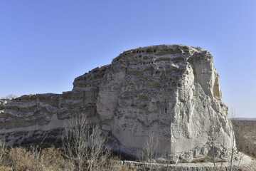 Large Rock Formation with Layered Structure Under Clear Sky