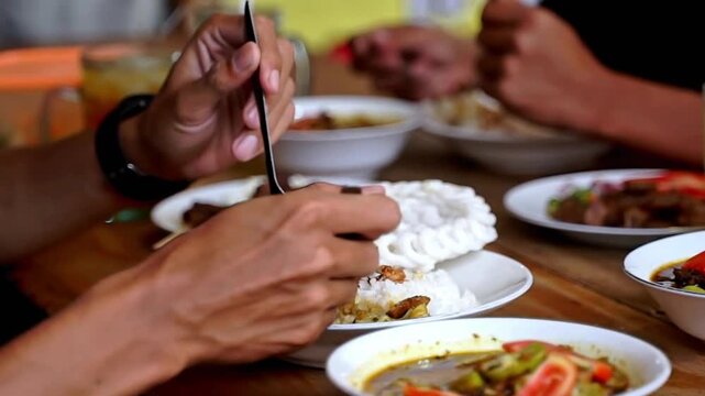 Close-up of Indonesian tongseng dish with rice, krupuk, and rich curry served at a local eatery. Authentic Asian cuisine, vibrant spices, and traditional street food culture.
