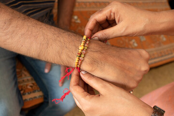 Raksha Bandhan - Rakhi festival close up of hand tying rakhi on hand india festival